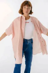 Camisa larga de lino con estampado floral azul sobre fondo beige. Posee cuello mao, mangas cortas con puños, botones metálicos a la vista y tajos laterales en el ruedo.