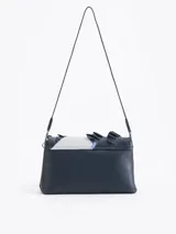 Cartera de hombro negra confeccionada en cuero vacuno, con diseño de solapa frontal decorada con volados de cuero y cierre metálico tipo candado.