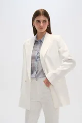 Blazer blanco de corte holgado, con cuello solapa, doble botonadura y bolsillos delanteros.