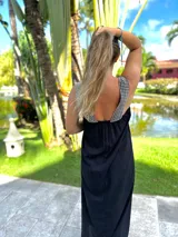 Vestido largo negro de fibrana, con breteles anchos y escote en V en la espalda. Presenta apliques de tachas plateadas en los breteles.