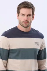 Remera de manga larga con diseño de rayas horizontales anchas en tonos verde, bordó y azul marino. Presenta cuello redondo y una pequeña estampa tipográfica en el pecho.