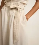 Pollera midi de corte clochard confeccionada en mezcla de viscosa y lino. Presenta cintura elástica con lazo ajustable del mismo tejido, bolsillos laterales y una caída fluida.