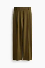 Pantalón verde militar de corte holgado, con pinzas delanteras, bolsillos laterales, bolsillos traseros decorativos y piernas amplias con pliegues marcados. Cuenta con cierre de botón y corchetes ocultos.