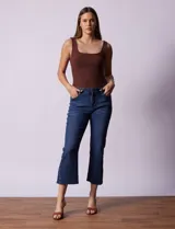 Pantalón jean azul oscuro, tiro alto, corte recto y terminación bootcut. Tiene bolsillos delanteros y traseros, pretina con pasadores, botón y cierre. Aplique de tachas en los laterales.