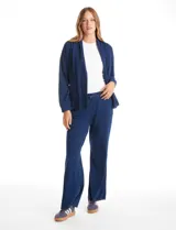 Cardigan abierto de denim, de corte holgado y recto, con solapas amplias, bolsillos frontales funcionales y hombros caídos.