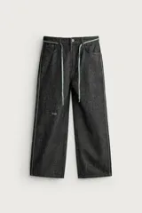 Jeans wide fit de denim negro, con costuras y detalles en color verde claro, bolsillos laterales y traseros, y cintura ajustable con cordón integrado.