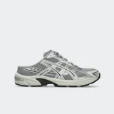 Championes Asics modelo Gel 1130 Mule, de diseño estilo zapatilla sin talón (mule), color gris y plateado, confeccionados con malla transpirable y detalles superpuestos.