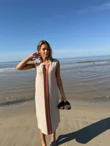 Vestido midi sin mangas color beige, con corte recto y detalle de franja vertical marrón en el centro.