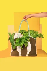 Bolso tipo tote de tela color crudo con detalles de cuero marrón en las asas y la base.