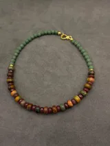 Collar artesanal corto con cuentas de piedras naturales facetadas en tonos tierra, marrones y verdes.