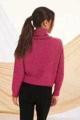 Polera de tejido de punto en color rosa, con cuello alto, mangas largas y puños acanalados.
