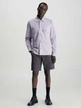 Shorts de corte slim color gris oscuro, confeccionados en sarga de algodón con elasticidad. Presentan talle medio, bragueta con cremallera, bolsillos laterales y de ojal en la parte trasera. Incluyen un cinturón con hebilla en forma de D.