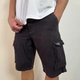 Bermuda cargo de jean color negro con múltiples bolsillos y corte a la rodilla.