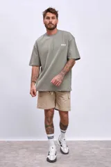 Remera de algodón color verde oliva, corte oversize, con cuello redondo y un pequeño logo bordado en el pecho.