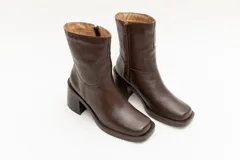 Bota de caña media color negro, de cuero, con punta cuadrada y taco bloque.