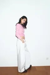 Jeans blancos de tiro medio con cinco bolsillos, detalle de costuras torcidas y cierre frontal con cremallera y botón metálico.