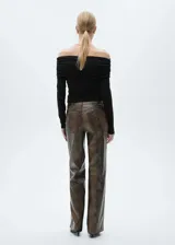 Pantalón de tiro medio con diseño recto y largo, confeccionado en material con efecto piel de serpiente. Cuenta con cierre delantero de cremallera y botón, trabillas para cinturón y bolsillos laterales.