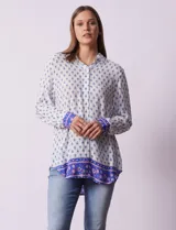 Camisa blanca con estampado floral en azul, de manga larga y cuello con solapa.