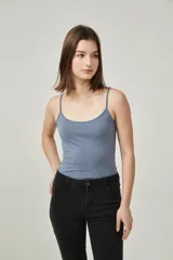 Musculosa de bretel fino color crudo, corte ajustado al cuerpo y escote redondo.