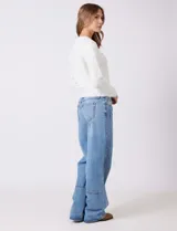 Jean de tiro medio y calce relajado, color azul claro, con bolsillos delanteros y traseros. Presenta recortes verticales en el frente y un recorte horizontal en el ruedo.