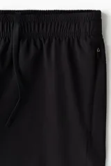 Pantalón deportivo negro de corte estándar y piernas rectas, confeccionado en tejido funcional ripstop con tecnología DryMove™. Cuenta con cintura elástica con cordón de ajuste oculto, bolsillos laterales con cierre y detalles perforados en las piernas.