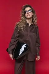 Camisa de manga larga con diseño de rayas verticales y horizontales en color marrón. Presenta un corte oversize con hombros caídos, cuello clásico y cierre frontal con botones.
