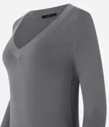 Suéter de punto color amarillo, con escote en V y mangas largas. Presenta un diseño básico y versátil, confeccionado en una mezcla de viscosa, poliamida y elastano.