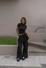 Minifalda negra de corte evasé con pretina elástica, bolsillos laterales y bolsillo trasero.