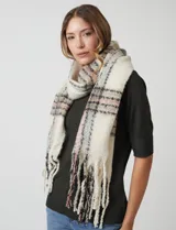 Bufandón de tejido soft, color crema con patrón a cuadros en tonos rosa pálido, gris y negro. Presenta terminación con flecos.