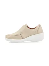 Zapato tipo slip-on color crudo, confeccionado en cuero, con cierre de velcro ajustable en el empeine, costuras visibles y suela de plataforma blanca.