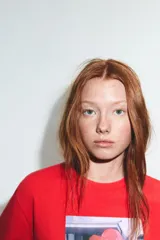 Camiseta de algodón color rojo, corte regular fit, cuello redondo y manga corta. Presenta una estampa fotográfica en el centro con dos personas sosteniendo un gran corazón rojo inflable. Incluye texto con nombre y copyright.