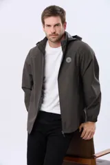 Campera repelente al agua y cortaviento de color negro, con capucha desmontable, cierre frontal y parche circular en el pecho.