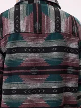 Camisa de manga larga con diseño de estampado étnico en tonos azules y beige. Presenta cuello clásico, cierre frontal con botones y bolsillos en el pecho.