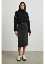 Sweater negro de punto con cuello alto y bordados blancos en sisas y mangas.