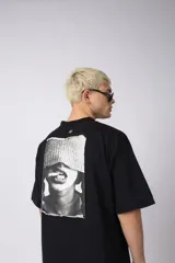 Remera oversize de algodón negro, con cuello redondo y manga corta ancha. Presenta un pequeño logo bordado en el pecho con un símbolo de prohibido fumar.