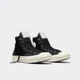 Championes Converse modelo Chuck 70 de caña alta, confeccionados en lona resistente con superposiciones de gamuza. Presentan suela de goma barnizada, cordones gruesos de algodón y el parche clásico de All Star en el lateral.
