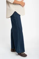 Jean de corte flare wide leg con tiro medio y ruedo desflecado. Confeccionado en denim de algodón, presenta un tono azul oscuro uniforme con costuras en contraste.