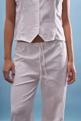 Pantalón blanco de corte ancho y tiro medio/bajo con cordón ajustable en la cintura.