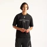 Remera negra de algodón New Balance modelo Trackside, con cuello redondo acanalado, mangas cortas y calce cuadrado. Presenta estampado gráfico en relieve con la marca en el centro del pecho.