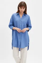 Camisa oversize de viscosa color azul, con cuello camisero, cierre frontal de botones, mangas largas y bolsillo aplicado en el pecho.