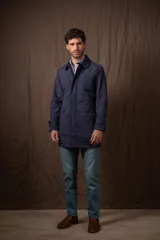 Trench azul marino de nylon, con cuello clásico, cierre frontal con botones y bolsillos laterales.