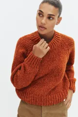 Jersey de punto de cuello redondo y manga larga, con diseño de tejido grueso y acabados en rib en cuello, puños y ruedo.
