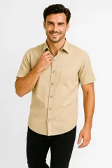 Camisa color beige de algodón con botones y cuello camisero, de manga corta y corte clásico.