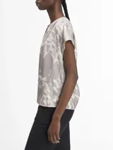 Blusa de satén gris con estampado abstracto en blanco, escote en V y mangas cortas.