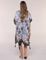 Kimono de gasa ligera con estampado floral en tonos marrones, amarillos y turquesas sobre base blanca, de corte amplio y abierto al frente, con mangas cortas tipo kimono y detalles de borlas en el ruedo asimétrico.