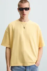 Camiseta gris de corte cuadrado y holgado, con cuello redondo y mangas cortas.