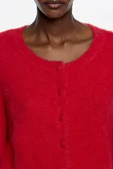 Sweater de punto de textura suave y afelpada, color rojo, con escote redondo y cierre frontal de botones al tono.