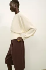 Jersey de cuello redondo color blanco, con manga larga tipo murciélago y acabados en rib elástico.