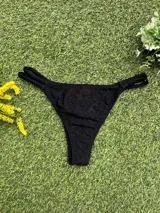 Bikini negra con corpiño triangular que tiene un aplique de piedra en el bretel y bombacha colaless con tiras ajustables laterales.