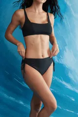 Conjunto de bikini negro de dos piezas con corpiño de escote cuadrado y tirantes finos, y bombacha vedetina con tiras laterales ajustables.